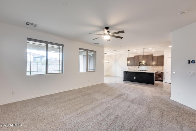 unfurnished living room with ceiling fan, recessed lighting, baseboards, and light carpet