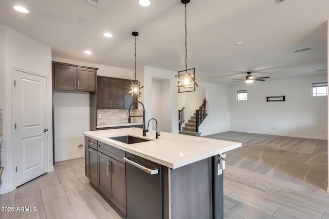 kitchen featuring backsplash, dark brown cabinetry, dishwasher, light countertops, and a sink