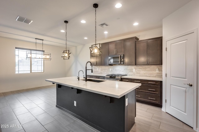 kitchen featuring visible vents, appliances with stainless steel finishes, a breakfast bar, and a sink