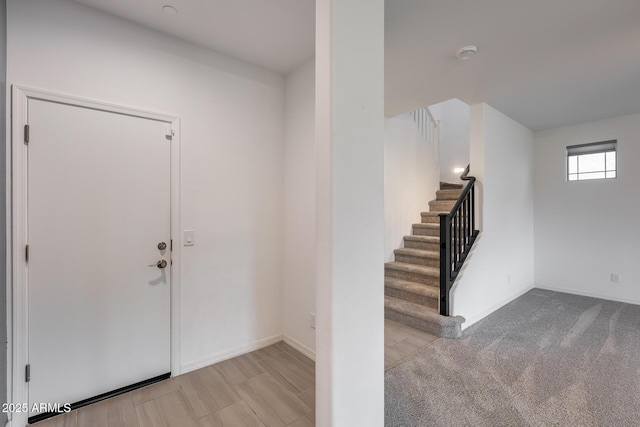 entryway featuring stairs and baseboards