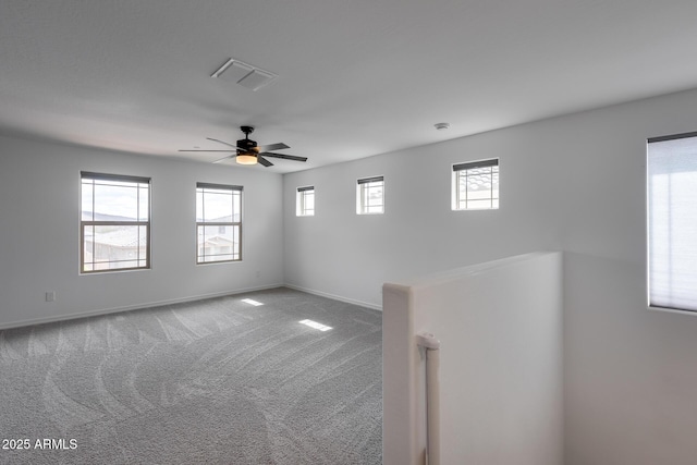 spare room featuring ceiling fan, carpet, visible vents, and baseboards