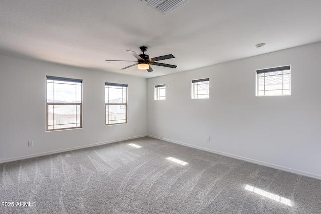 carpeted empty room featuring visible vents, baseboards, and ceiling fan