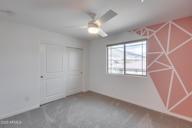 unfurnished bedroom featuring a closet, ceiling fan, baseboards, and carpet floors