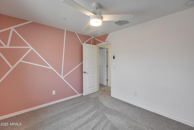 carpeted empty room with baseboards, visible vents, and ceiling fan