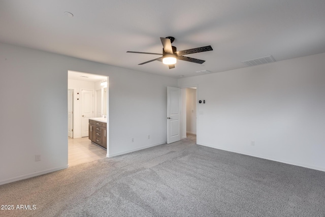 unfurnished bedroom with baseboards, visible vents, ceiling fan, ensuite bathroom, and light carpet