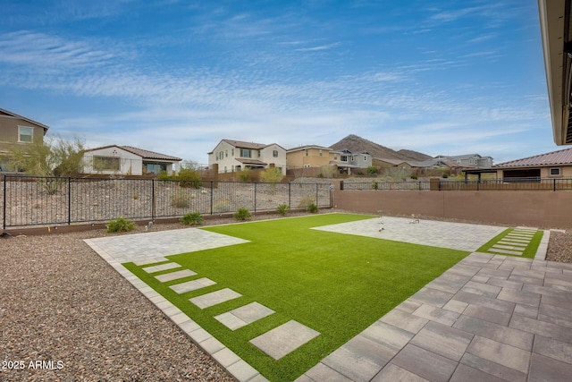 view of yard featuring a residential view, a patio, and a fenced backyard