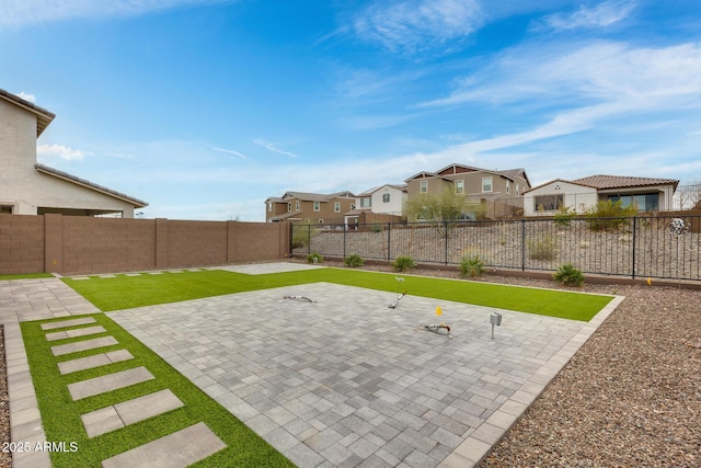 view of yard with a residential view, a patio, and a fenced backyard