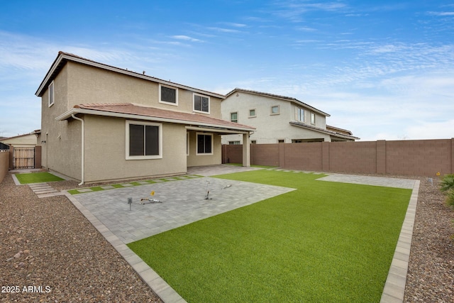 back of property with a patio, a fenced backyard, a lawn, and stucco siding