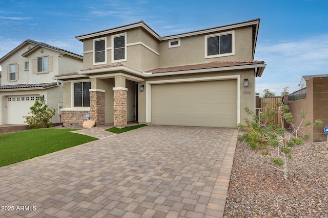 view of front of home featuring stucco siding, decorative driveway, an attached garage, and fence