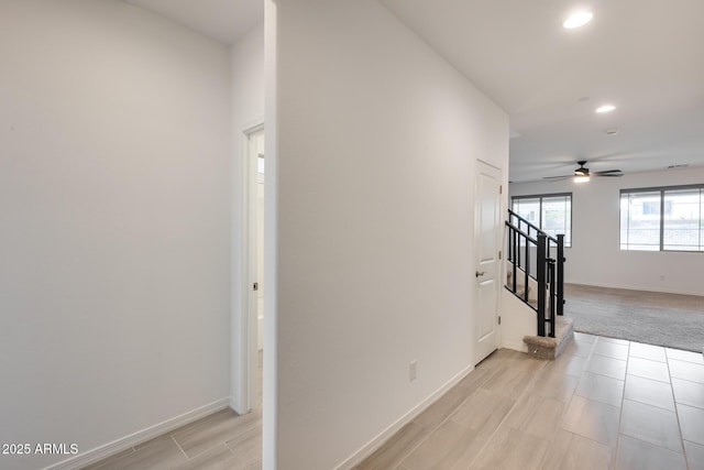 corridor featuring light colored carpet, stairway, recessed lighting, and baseboards