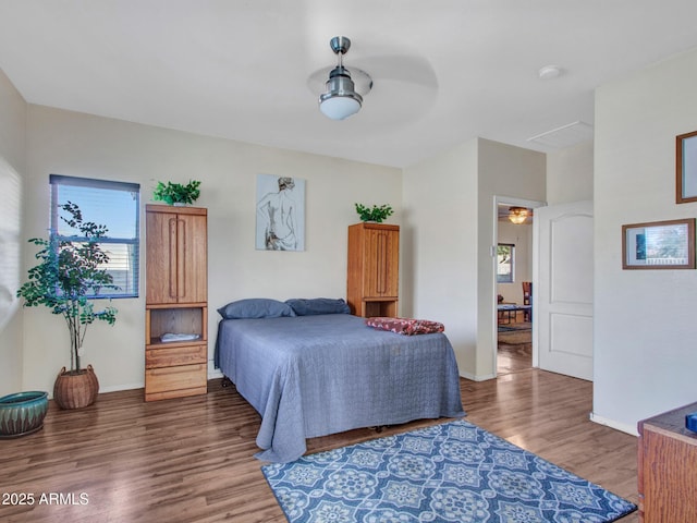 bedroom with wood finished floors and baseboards