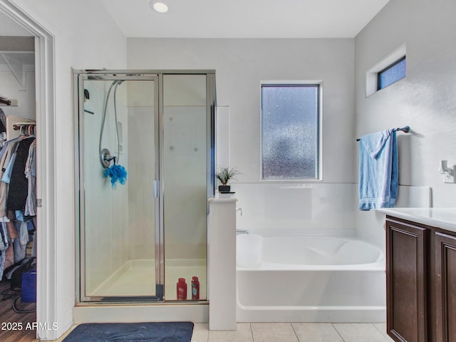 bathroom featuring a garden tub, a shower stall, vanity, and tile patterned floors