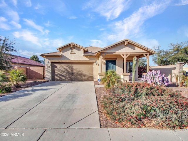 mediterranean / spanish home with driveway, a tiled roof, an attached garage, fence, and stucco siding