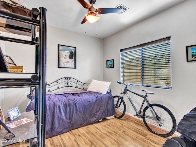 bedroom with visible vents, ceiling fan, baseboards, and wood finished floors