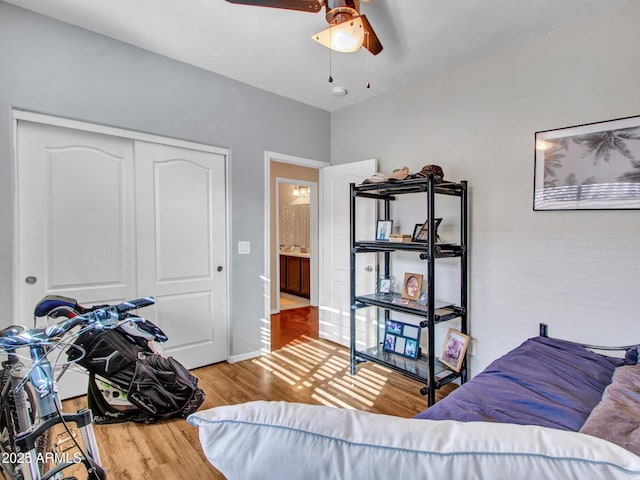 bedroom featuring a closet, wood finished floors, a ceiling fan, and baseboards