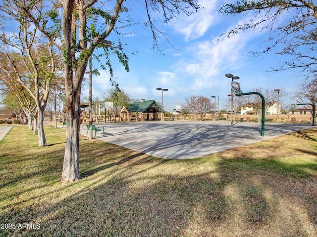 view of basketball court with community basketball court and a lawn