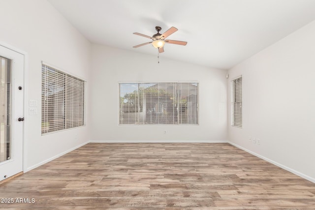 spare room with lofted ceiling, baseboards, a ceiling fan, and wood finished floors