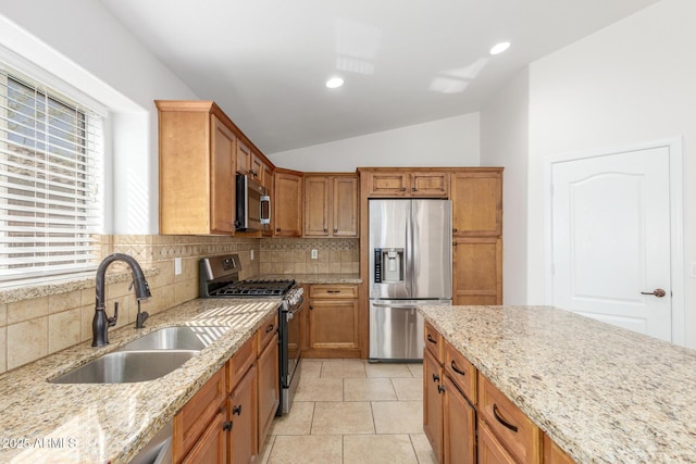 kitchen featuring backsplash, vaulted ceiling, stainless steel appliances, and a sink