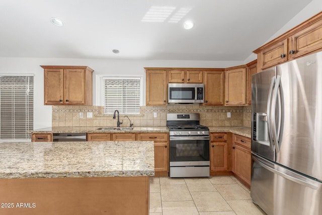 kitchen featuring tasteful backsplash, light tile patterned floors, stainless steel appliances, and a sink