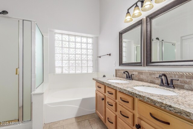 bathroom with a shower stall, a bath, a sink, and double vanity