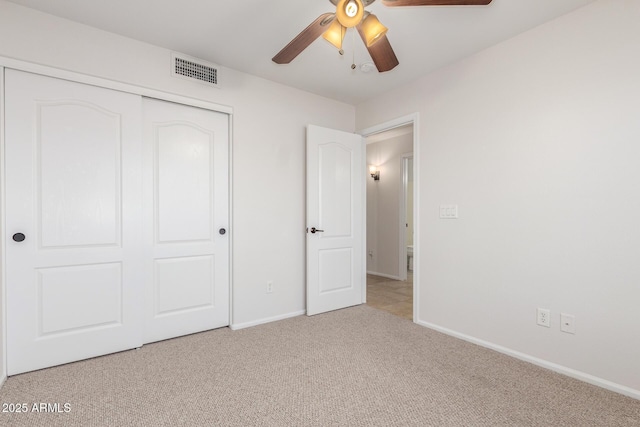 unfurnished bedroom featuring visible vents, carpet floors, a closet, baseboards, and ceiling fan