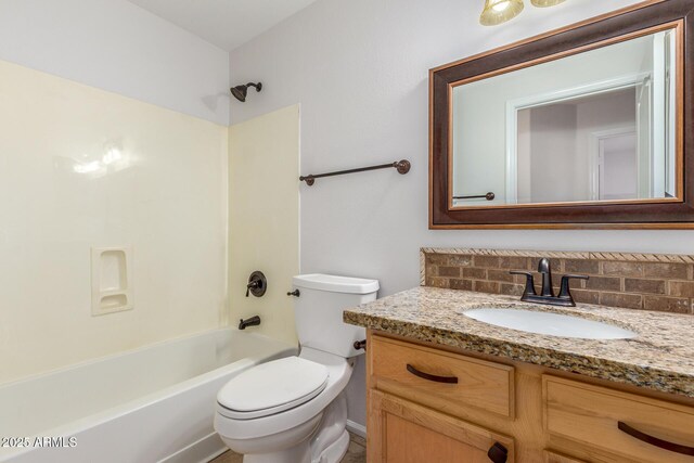 bathroom featuring backsplash, washtub / shower combination, toilet, and vanity