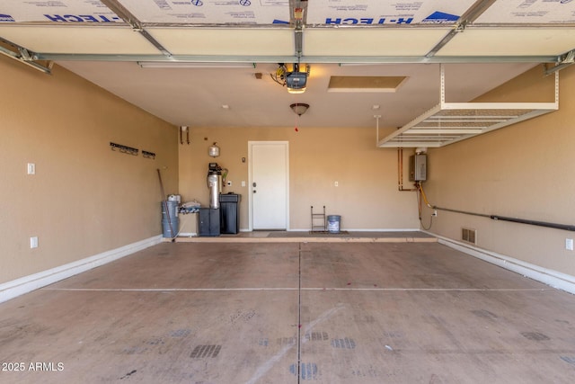 garage with visible vents, baseboards, and a garage door opener