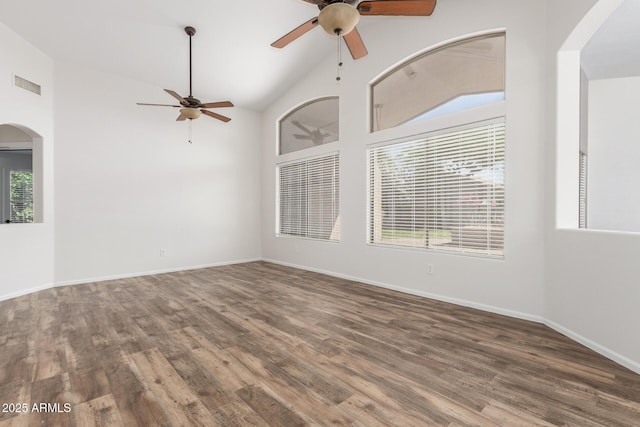 unfurnished room with arched walkways, a ceiling fan, wood finished floors, and visible vents