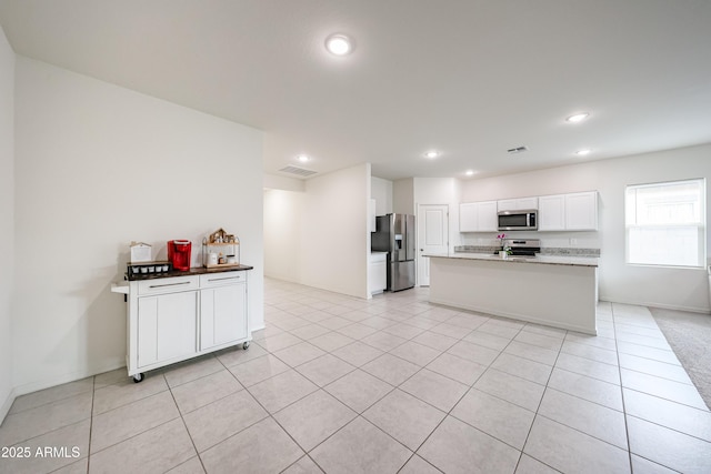 5721 W Coplen Farms Rd, Laveen, AZ 85339 - kitchen featuring stainless steel appliances, white cabinetry, light tile patterned floors, recessed lighting, and a center island with sink