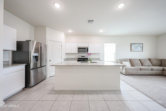 5721 W Coplen Farms Rd, Laveen, AZ 85339 - kitchen with stainless steel appliances, light tile patterned floors, white cabinets, a sink, and light stone counters