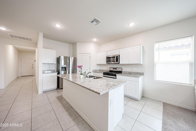 5721 W Coplen Farms Rd, Laveen, AZ 85339 - kitchen featuring appliances with stainless steel finishes, a sink, light tile patterned floors, a kitchen island with sink, and white cabinetry