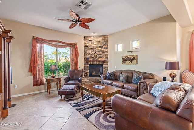 tiled living room with ceiling fan and a fireplace