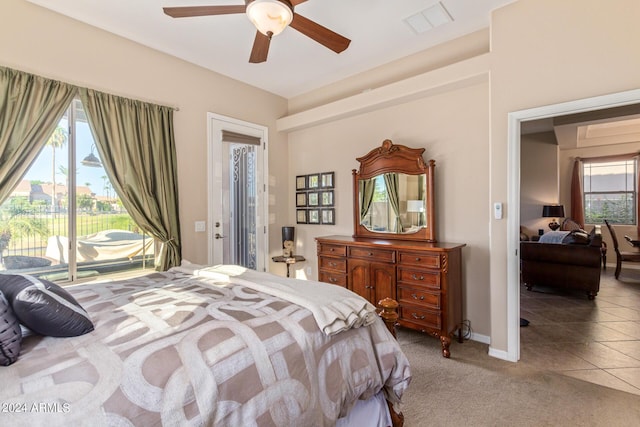 bedroom with multiple windows, access to outside, light colored carpet, and ceiling fan