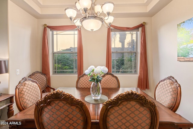 dining room with an inviting chandelier, a tray ceiling, and a wealth of natural light