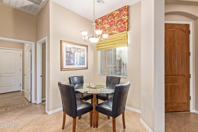 tiled dining area featuring a chandelier