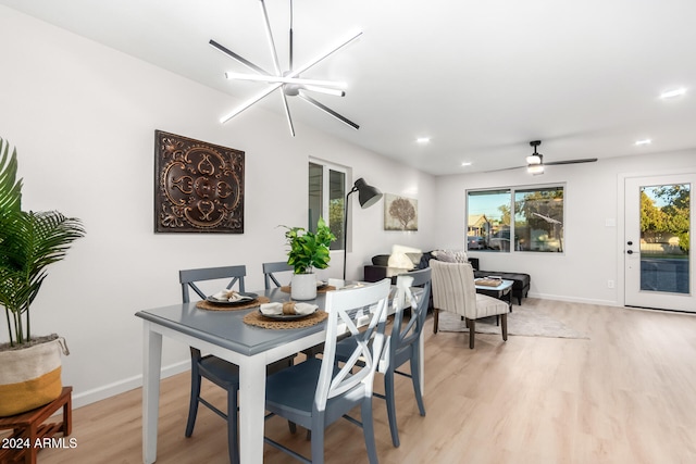 dining room featuring light hardwood / wood-style floors and ceiling fan with notable chandelier