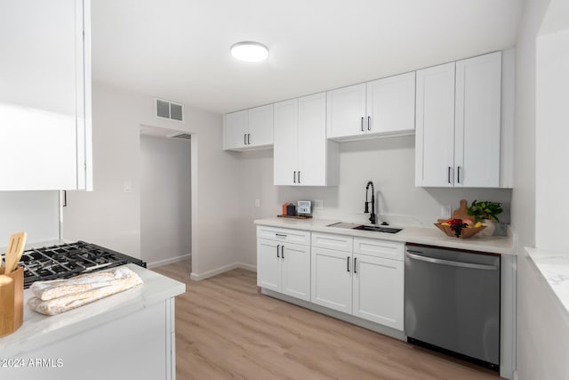 kitchen with light hardwood / wood-style floors, white cabinetry, sink, light stone countertops, and dishwasher