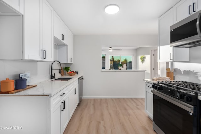 kitchen featuring white cabinets, stainless steel appliances, light hardwood / wood-style floors, and sink