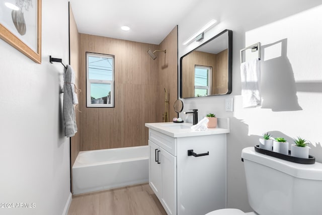 full bathroom featuring hardwood / wood-style floors, tiled shower / bath, a healthy amount of sunlight, and vanity