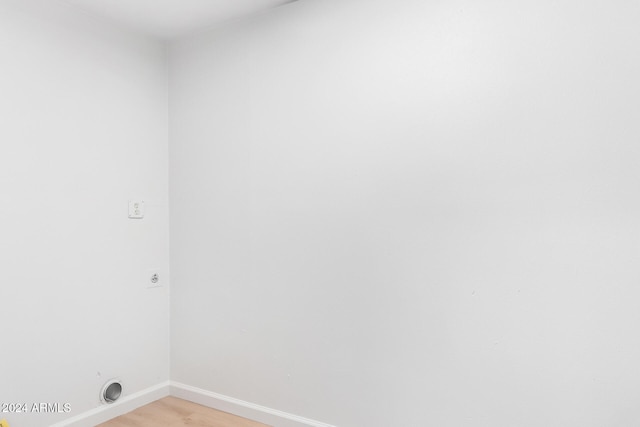 clothes washing area with electric dryer hookup and light hardwood / wood-style floors