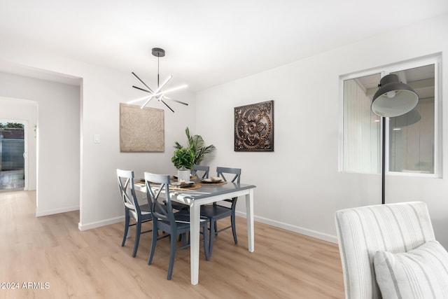 dining room featuring light wood-type flooring and an inviting chandelier