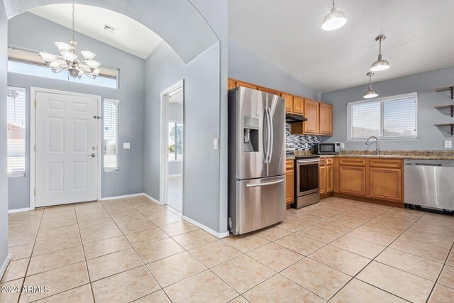 kitchen with vaulted ceiling, hanging light fixtures, light hardwood / wood-style floors, stainless steel dishwasher, and ceiling fan