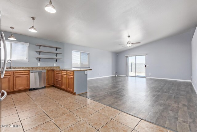 kitchen with appliances with stainless steel finishes, tasteful backsplash, vaulted ceiling, sink, and kitchen peninsula