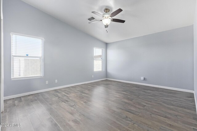 unfurnished bedroom with wood-type flooring, a towering ceiling, and ceiling fan