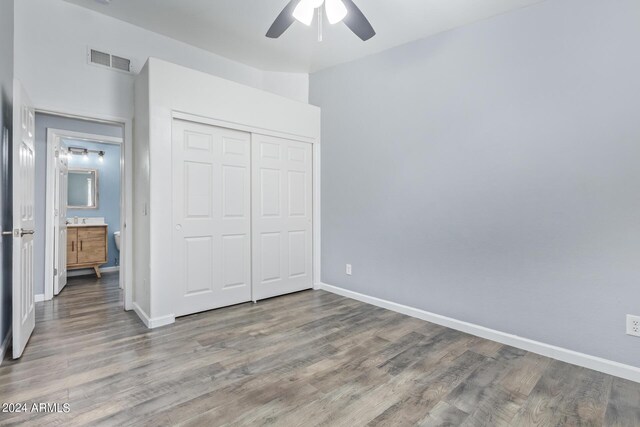 unfurnished bedroom with ceiling fan, hardwood / wood-style flooring, and a closet