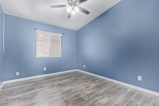 unfurnished bedroom featuring ceiling fan, lofted ceiling, hardwood / wood-style floors, and a closet