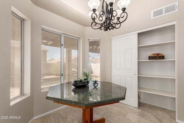 dining space with a chandelier, baseboards, and light tile patterned floors