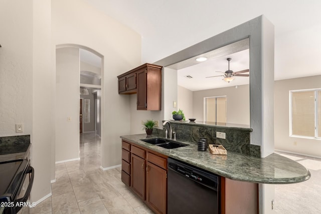 kitchen featuring black appliances, a sink, arched walkways, ceiling fan, and baseboards