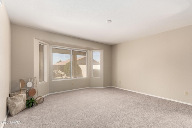 carpeted empty room with baseboards