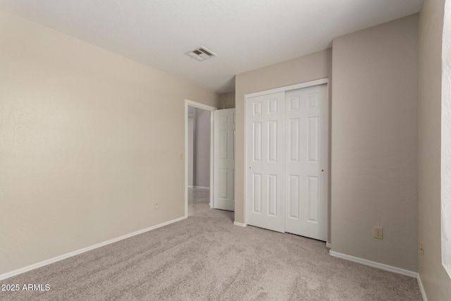 unfurnished bedroom featuring carpet floors, baseboards, and a closet